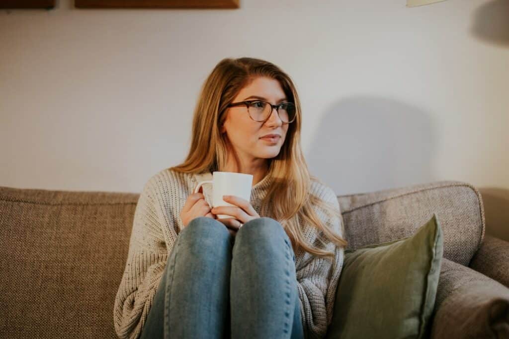 Woman with a cup of coffee on a couch